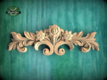 Load image into Gallery viewer, a wooden carving of flowers and leaves on a green background