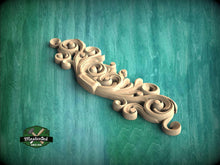 Load image into Gallery viewer, a wood carving of a scroll on a green background