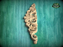 Load image into Gallery viewer, A decorative wooden carving with intricate swirls and patterns is displayed against a green background.