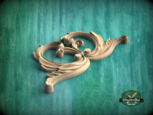 Load image into Gallery viewer, A decorative wooden carving with an ornate, swirling design is displayed against a green textured background.