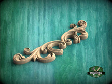 Load image into Gallery viewer, a wood carving of a scroll on a green background