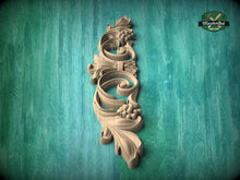 Load image into Gallery viewer, A decorative wooden carving in the shape of a flower or leaf is displayed against a teal-colored background.