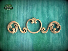 Load image into Gallery viewer, A decorative wooden scrollwork piece with intricate scrollwork designs is displayed against a green textured background.