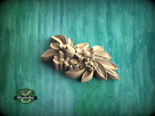 Load image into Gallery viewer, A wooden carving of a flower on a green background.