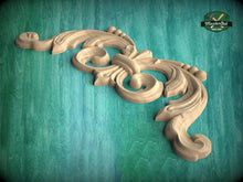 Load image into Gallery viewer, A decorative wooden carving with intricate scrollwork is displayed against a teal background.