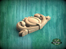 Load image into Gallery viewer, A wooden carving with intricate designs is displayed against a green background.