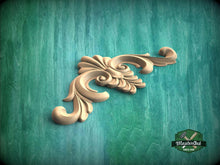 Load image into Gallery viewer, a wood carving of a flower on a green background