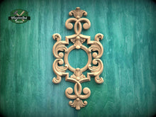 Load image into Gallery viewer, an ornate, carved wooden frame with intricate scrollwork and floral designs, set against a green textured background.
