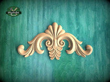 Load image into Gallery viewer, a wooden carving of a flower on a green background