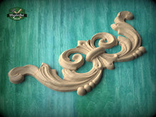 Load image into Gallery viewer, A decorative wooden carving with intricate scrollwork is displayed against a teal background.