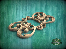 Load image into Gallery viewer, A decorative wooden carving with intricate scrollwork is displayed against a teal background.