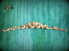 Load image into Gallery viewer, a wooden carving of a flower on a green background