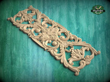 Load image into Gallery viewer, an ornate, carved wooden piece with intricate floral and scroll designs, set against a green background.