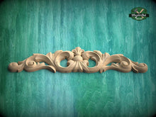 Load image into Gallery viewer, A decorative wooden carving with intricate scrollwork is displayed against a teal-colored background.