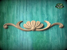 Load image into Gallery viewer, A wooden carving of a shell-like design is displayed against a teal-colored background.