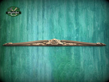 Load image into Gallery viewer, A decorative wooden molding or panel with an ornate design is displayed against a textured green background.