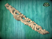 Load image into Gallery viewer, A decorative wooden carving with intricate floral patterns is displayed against a green textured background.