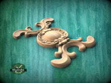 Load image into Gallery viewer, A wooden carving with an ornate, decorative design is displayed against a green background.