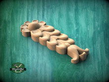Load image into Gallery viewer, A wooden carving of a flower-like shape is displayed against a green background.