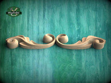 Load image into Gallery viewer, a pair of carved wooden handles on a green background