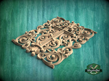 Load image into Gallery viewer, an intricate, ornate carving of a cross with swirling, organic shapes and patterns, set against a green background.