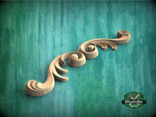 Load image into Gallery viewer, a wood carving of a scroll on a green background