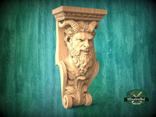 Load image into Gallery viewer, A carved wooden sculpture of a bearded, horned figure with an intense expression, mounted on a wooden bracket against a green background.