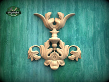 Load image into Gallery viewer, a decorative wooden carving on a green background.