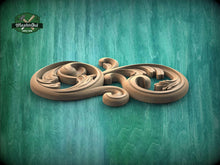 Load image into Gallery viewer, A wooden carving with an intricate, swirling design is displayed against a teal-colored background.