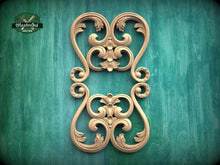 Load image into Gallery viewer, a decorative wooden carving with intricate scrollwork and floral designs, set against a green background.