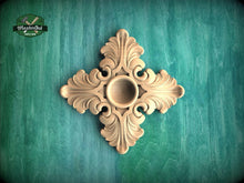Load image into Gallery viewer, a decorative wooden piece with an intricate design, placed against a green background.