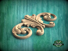 Load image into Gallery viewer, A carved wooden design with intricate scrollwork is displayed against a green background.