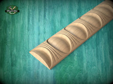 Load image into Gallery viewer, A wooden carving with a curved, organic shape is displayed against a teal-colored background.