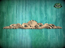 Load image into Gallery viewer, A decorative wooden carving with a shell-like design is displayed against a teal-colored background.