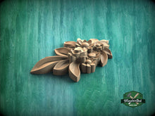 Load image into Gallery viewer, A wooden carving of a flower-like shape is displayed against a green background.