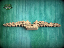 Load image into Gallery viewer, a wooden carving of a dragon on a green background