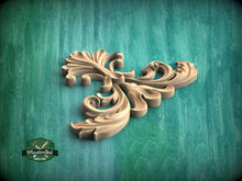 Load image into Gallery viewer, A decorative wooden carving in the shape of a stylized flower or leaf is displayed against a green background.