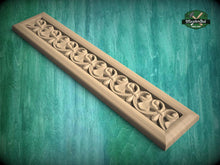 Load image into Gallery viewer, A decorative wooden panel with a floral pattern, displayed on a green textured background.