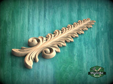 Load image into Gallery viewer, A decorative wooden leaf-like object with intricate scrollwork is displayed against a green background.