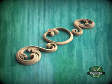 Load image into Gallery viewer, A decorative wooden carving in the shape of a flower is displayed against a green background.