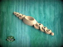 Load image into Gallery viewer, a wooden spoon sitting on top of a green table