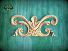 Load image into Gallery viewer, a decorative wooden carving on a green background.