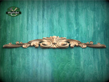 Load image into Gallery viewer, a green wall with a wooden carving on it