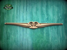 Load image into Gallery viewer, A decorative wooden object with a curved, ornate design is displayed against a green textured background.