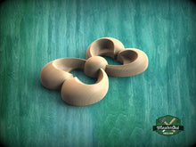 Load image into Gallery viewer, A wooden sculpture in the shape of a flower, with curved petals and a round center, is displayed against a green background.