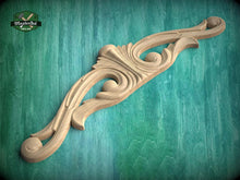 Load image into Gallery viewer, A wooden carving with an intricate, decorative design is displayed against a green background.