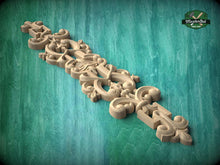 Load image into Gallery viewer, A decorative wooden carving with intricate scrollwork and floral designs is displayed against a green background.