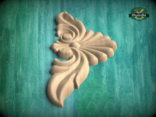 Load image into Gallery viewer, A decorative wooden carving in the shape of a flower or leaf is displayed against a green background.
