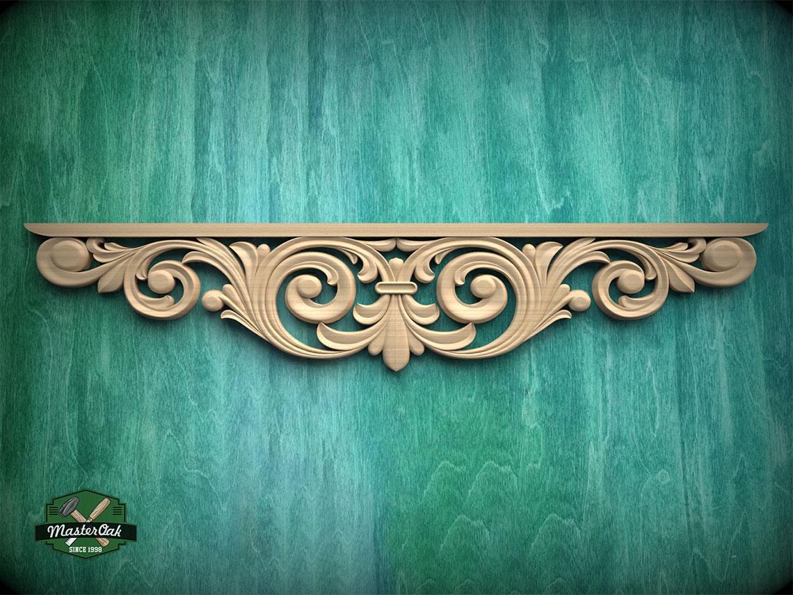a decorative wooden carving on a green wooden surface.