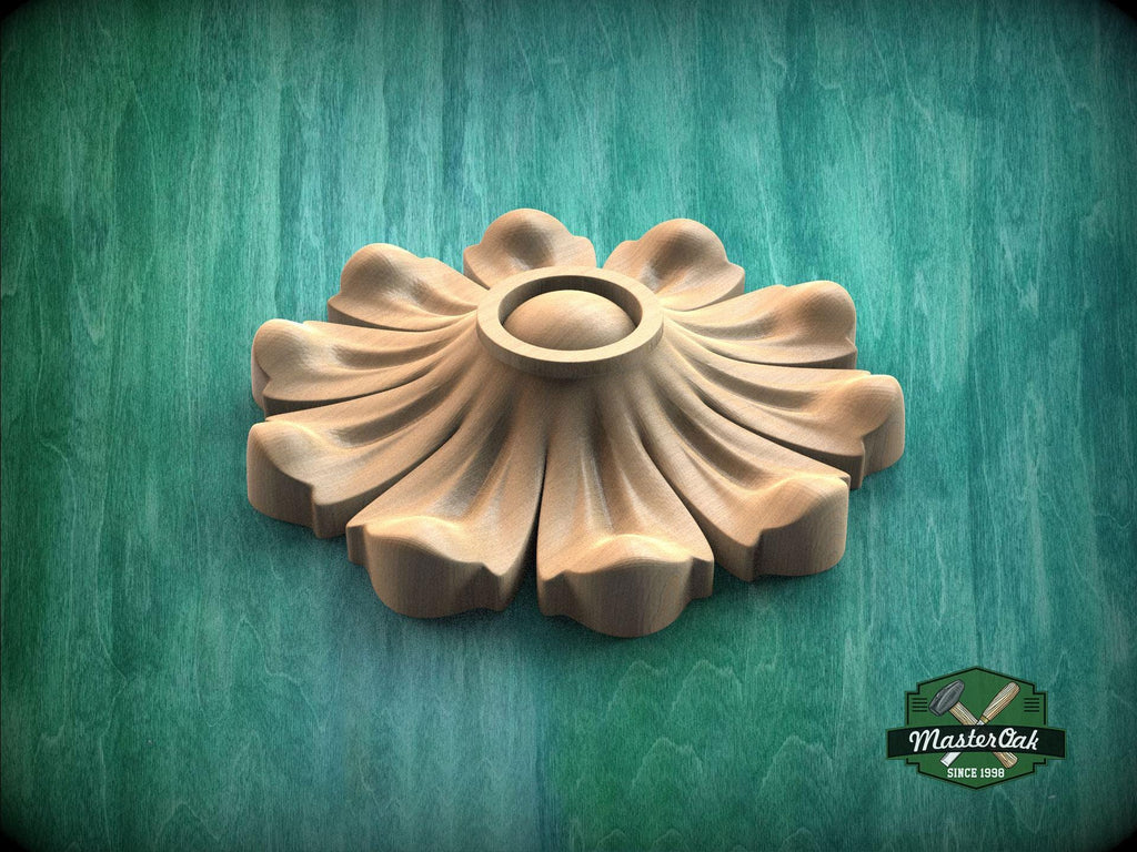 A wooden carving of a flower-like design is displayed against a green background.
